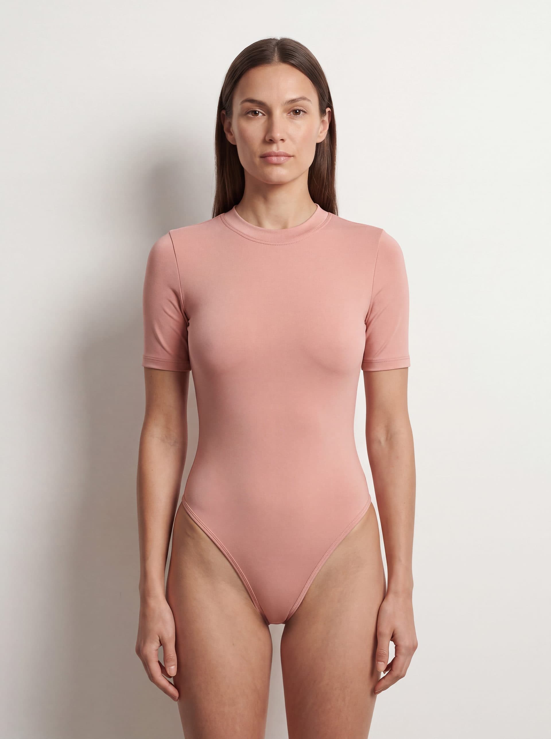 Body manga corta cuello cerrado, en color rosado, puesto en modelo
