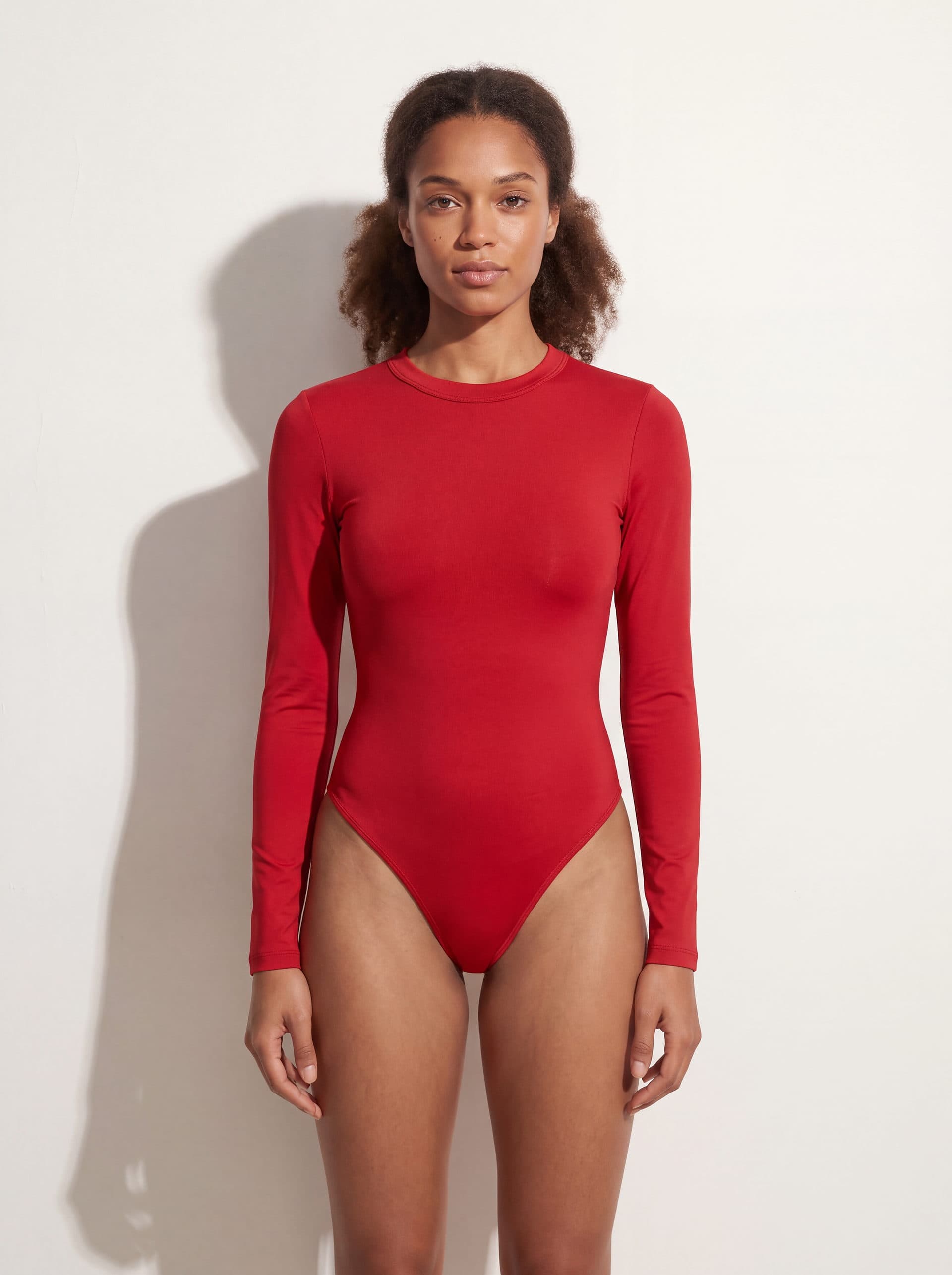 Body manga larga cuello redondo, en color rojo, puesto en modelo