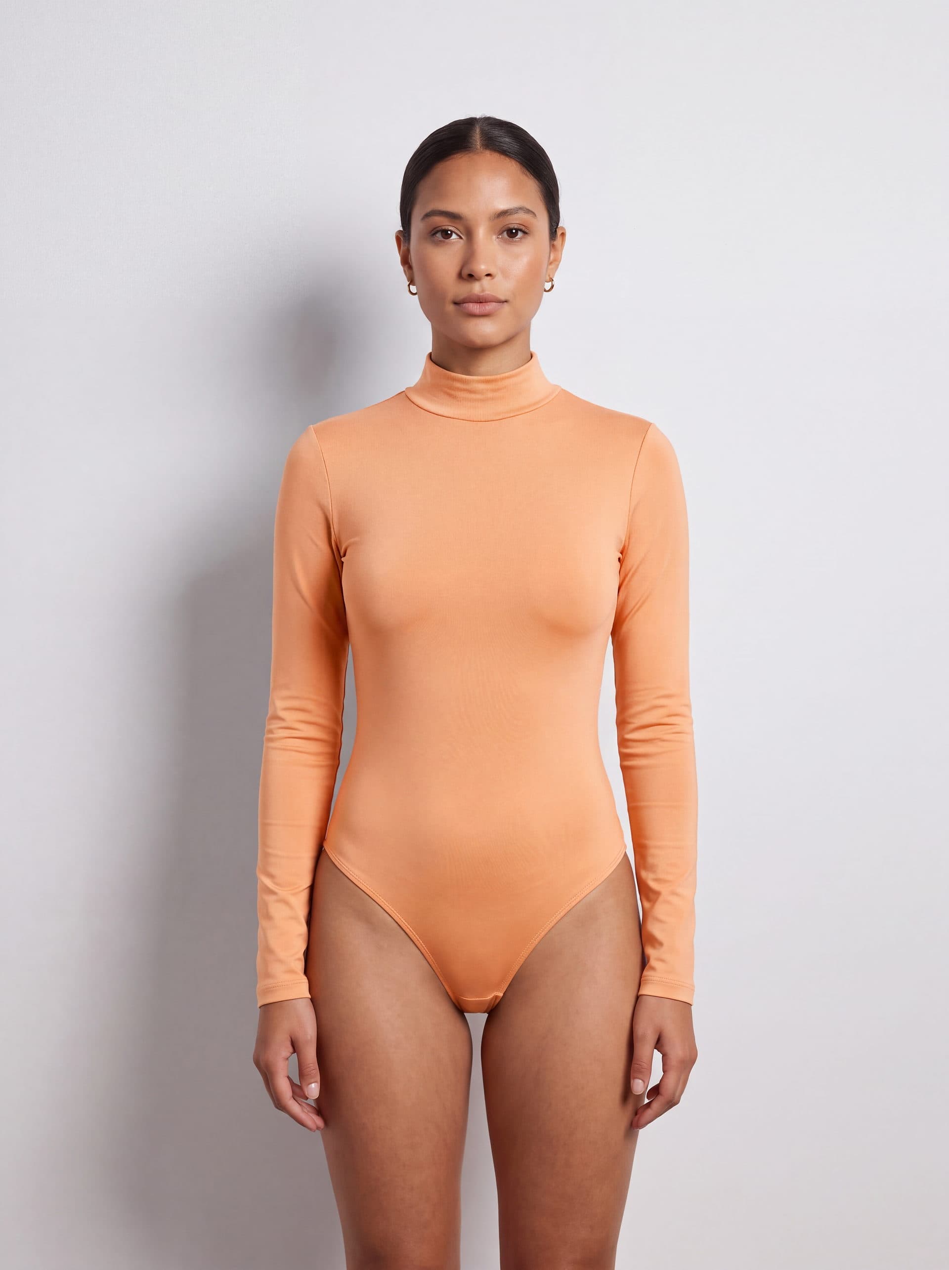 Body manga larga cuello tortuga, en color durazno, puesto en modelo