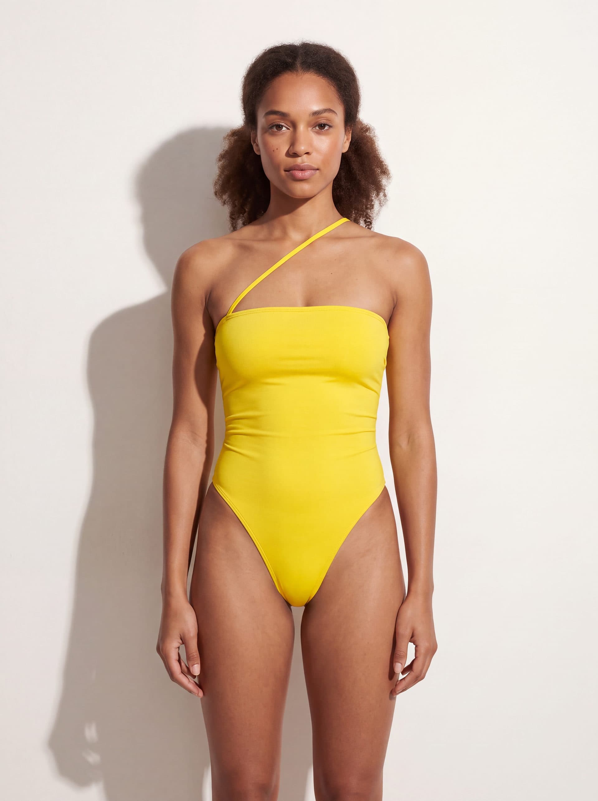 Body sin mangas con tirante diagonal, en color amarillo, puesto en modelo
