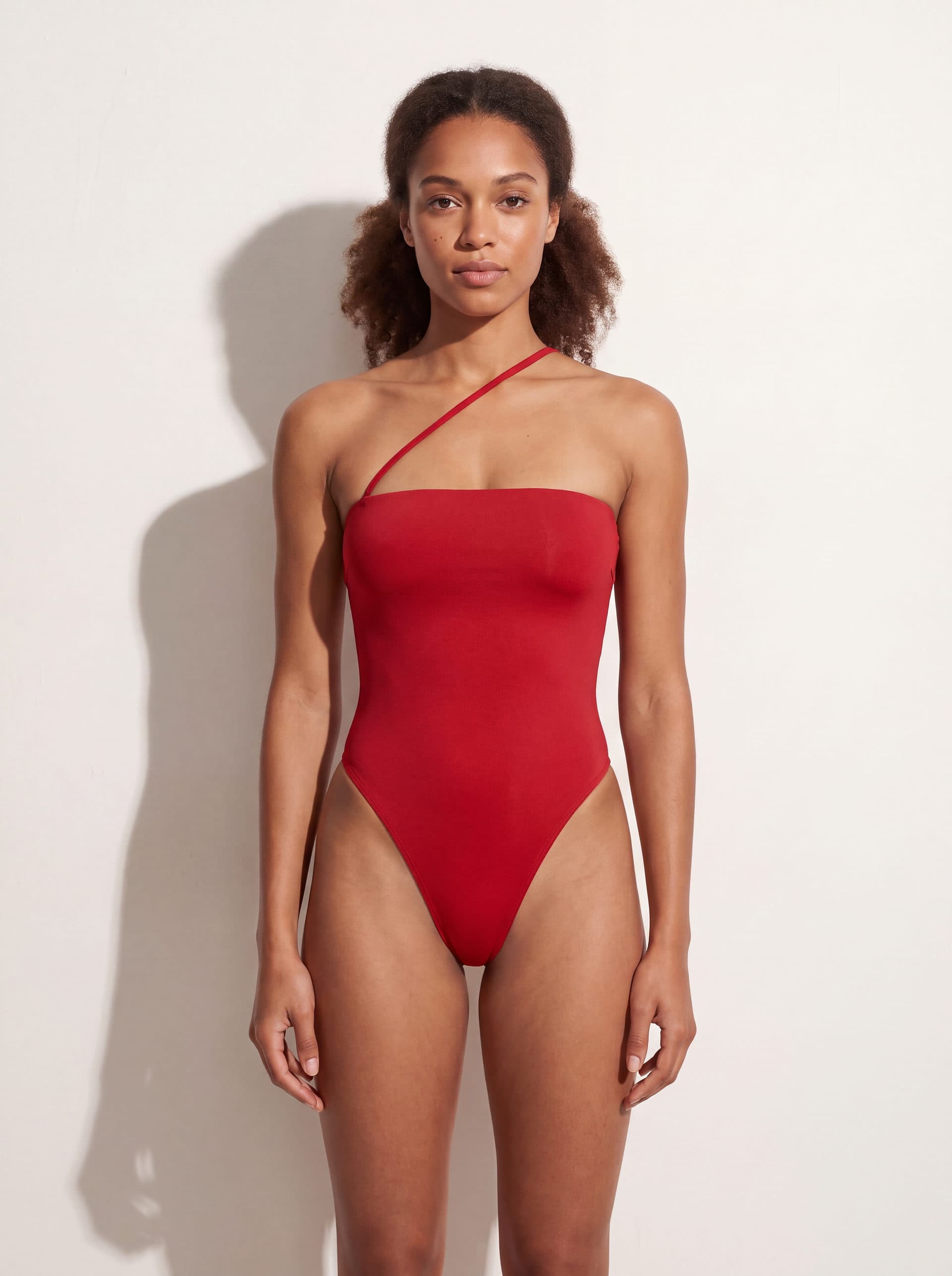 Body sin mangas con tirante diagonal, en color rojo, puesto en modelo
