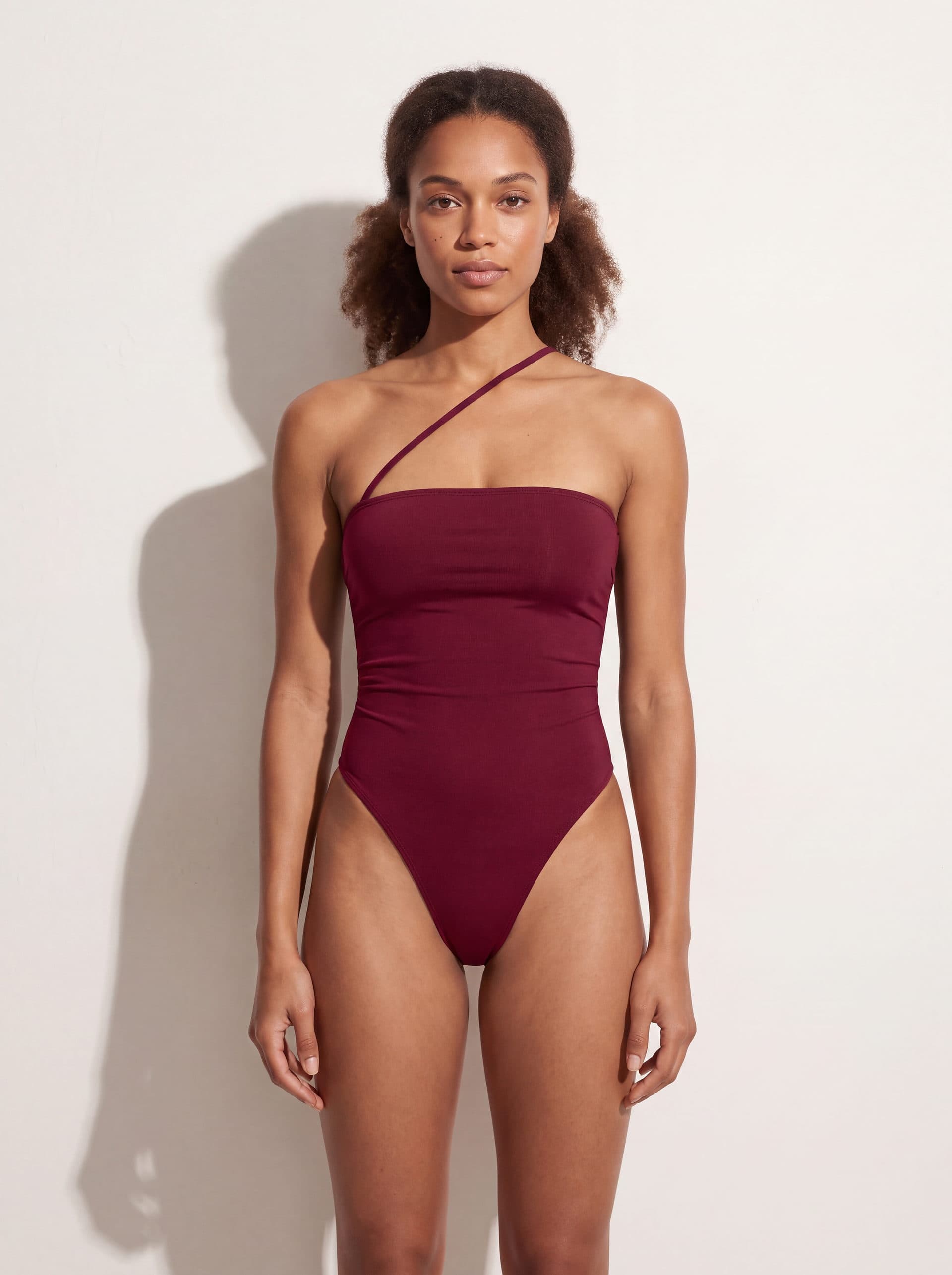Body sin mangas con tirante diagonal, en color vino tinto, puesto en modelo