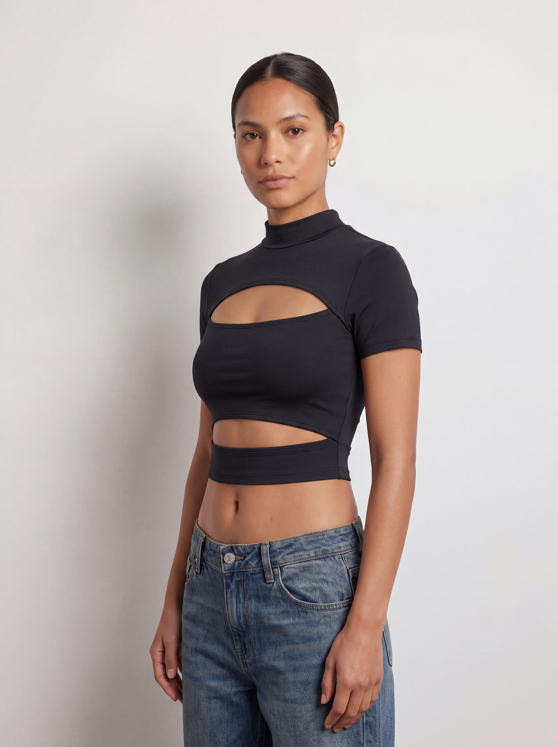 Crop top con doble abertura, en color negro, en modelo, vista de tres cuartos