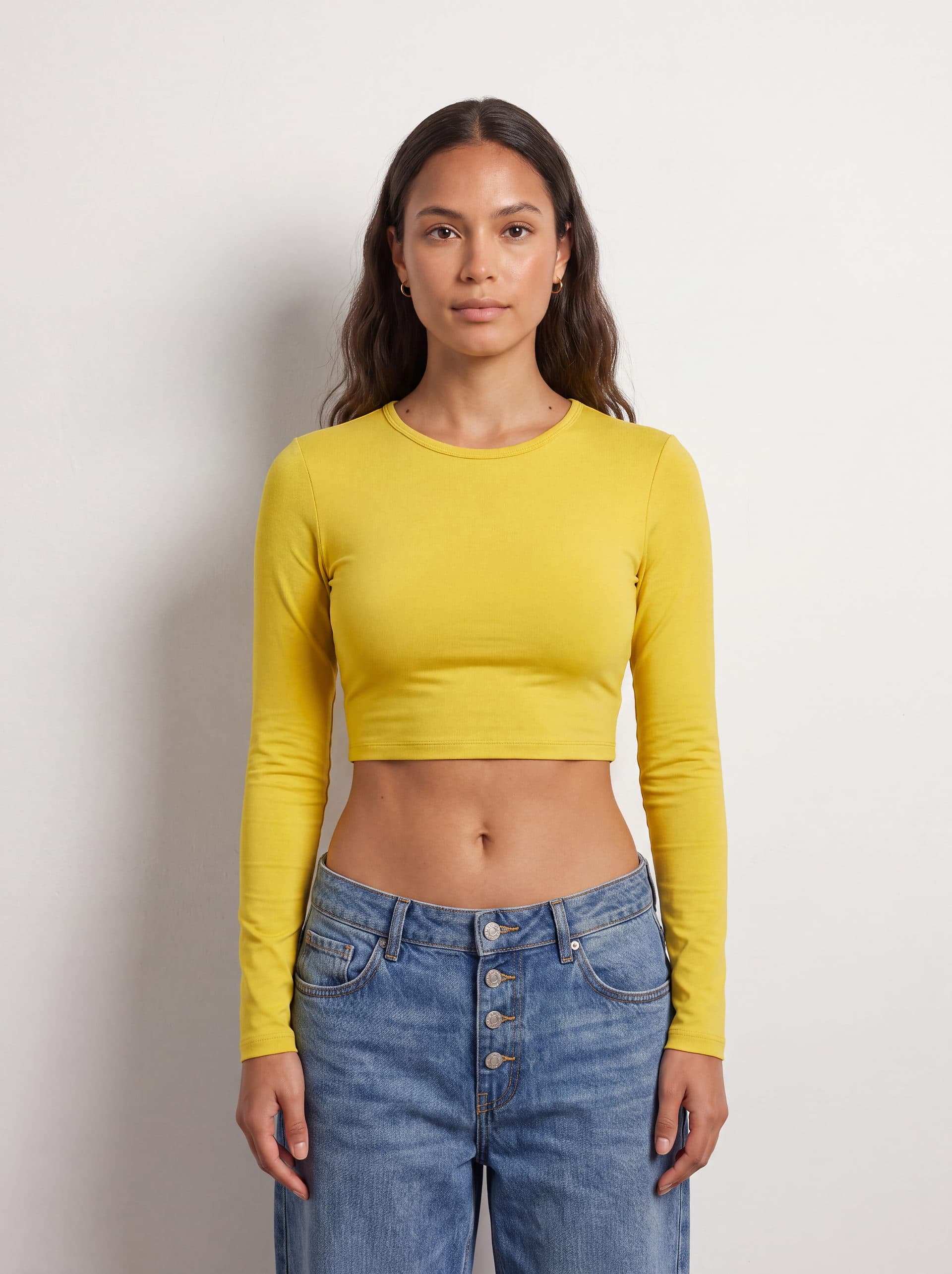 Crop top manga larga, en color amarillo, puesto en modelo