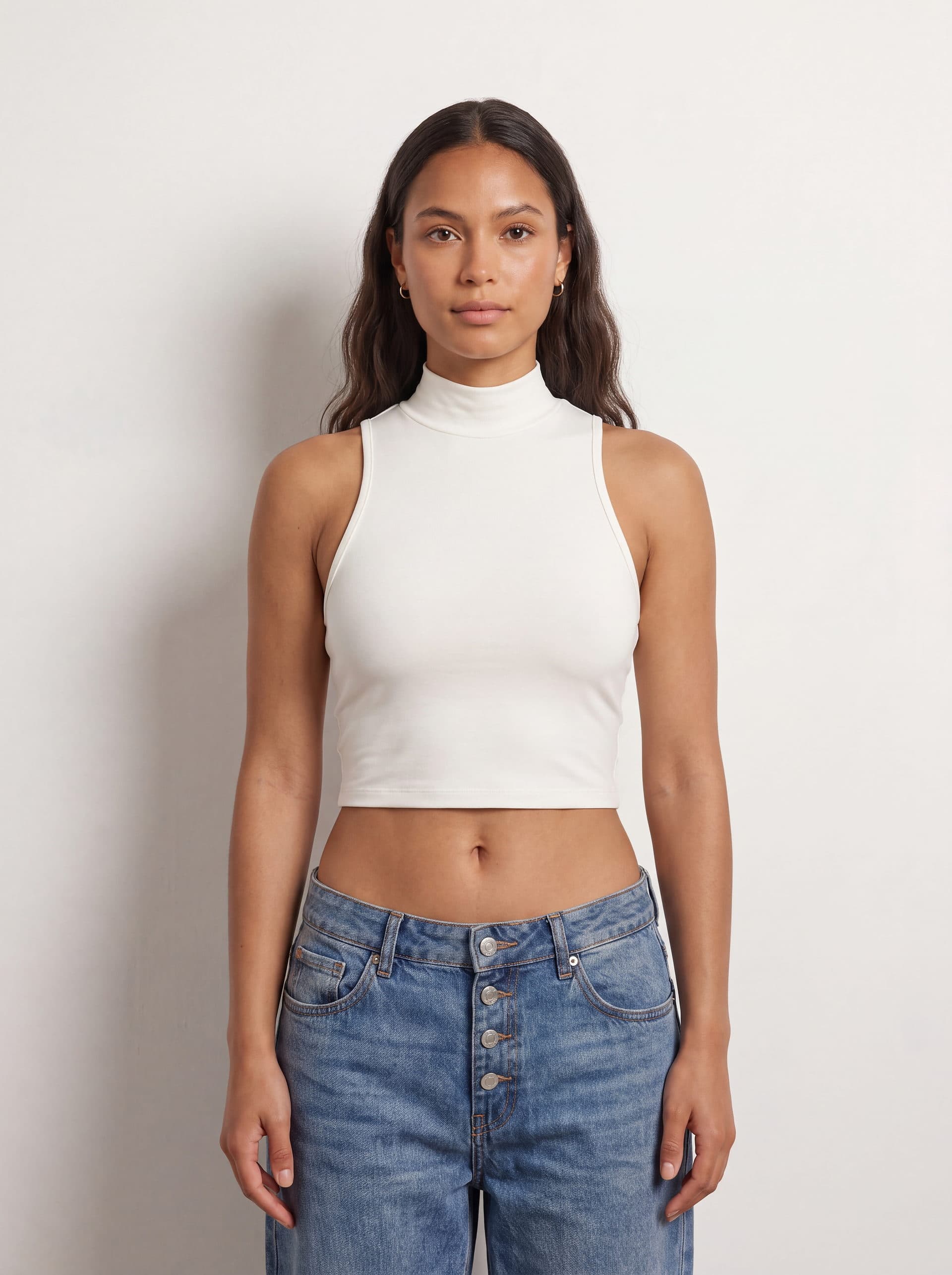 Crop top sin mangas cuello tortuga, en color blanco, puesto en modelo