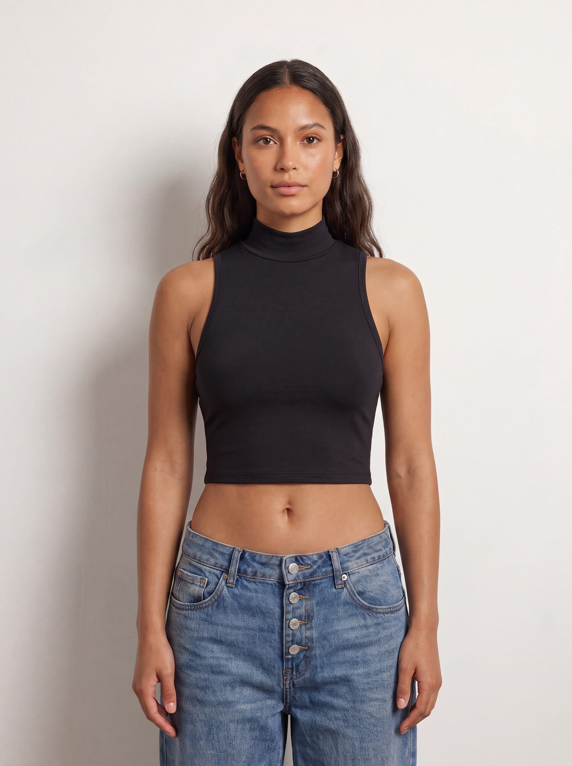 Crop top sin mangas cuello tortuga, en color negro, puesto en modelo