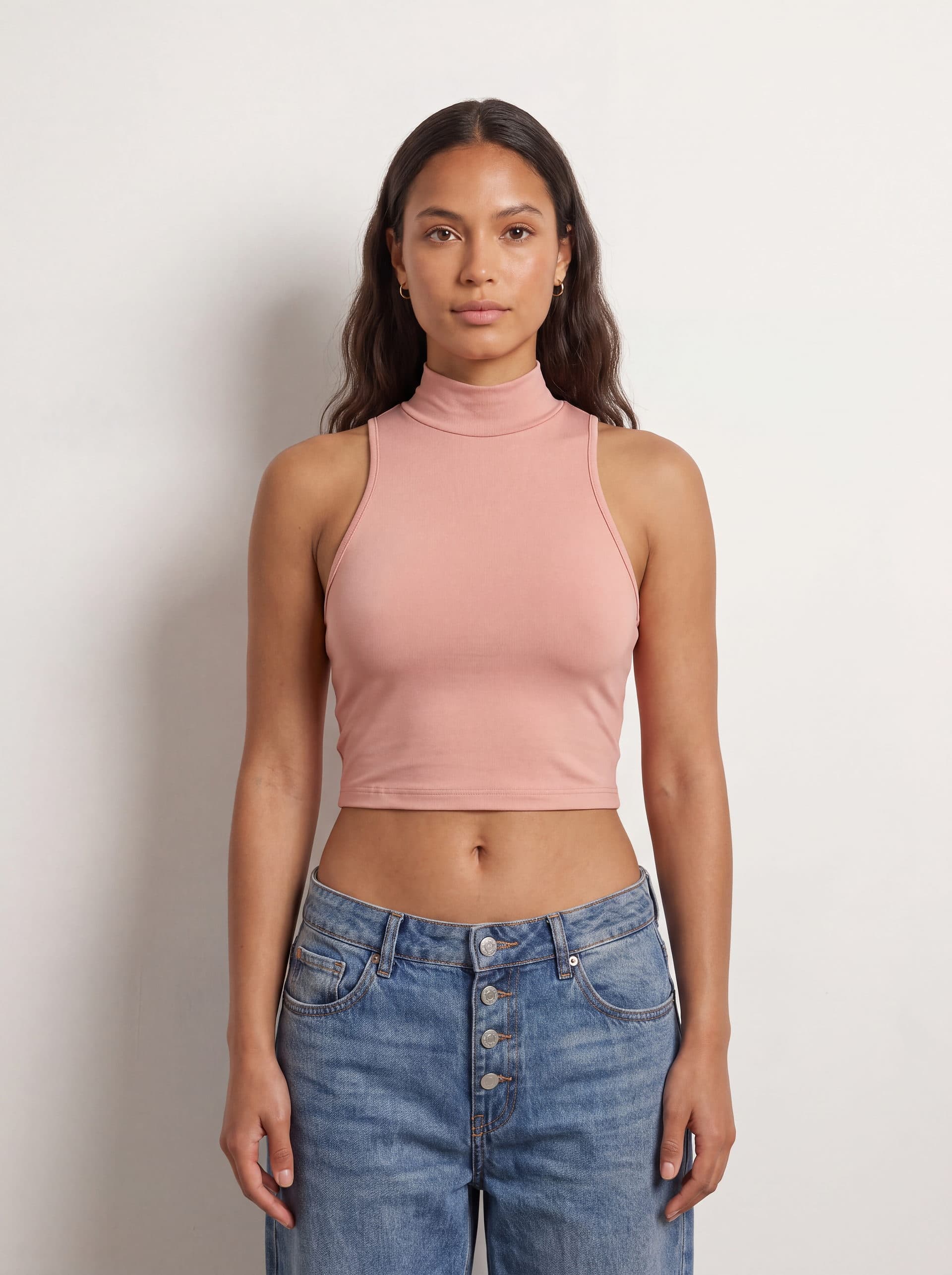 Crop top sin mangas cuello tortuga, en color rosado, puesto en modelo