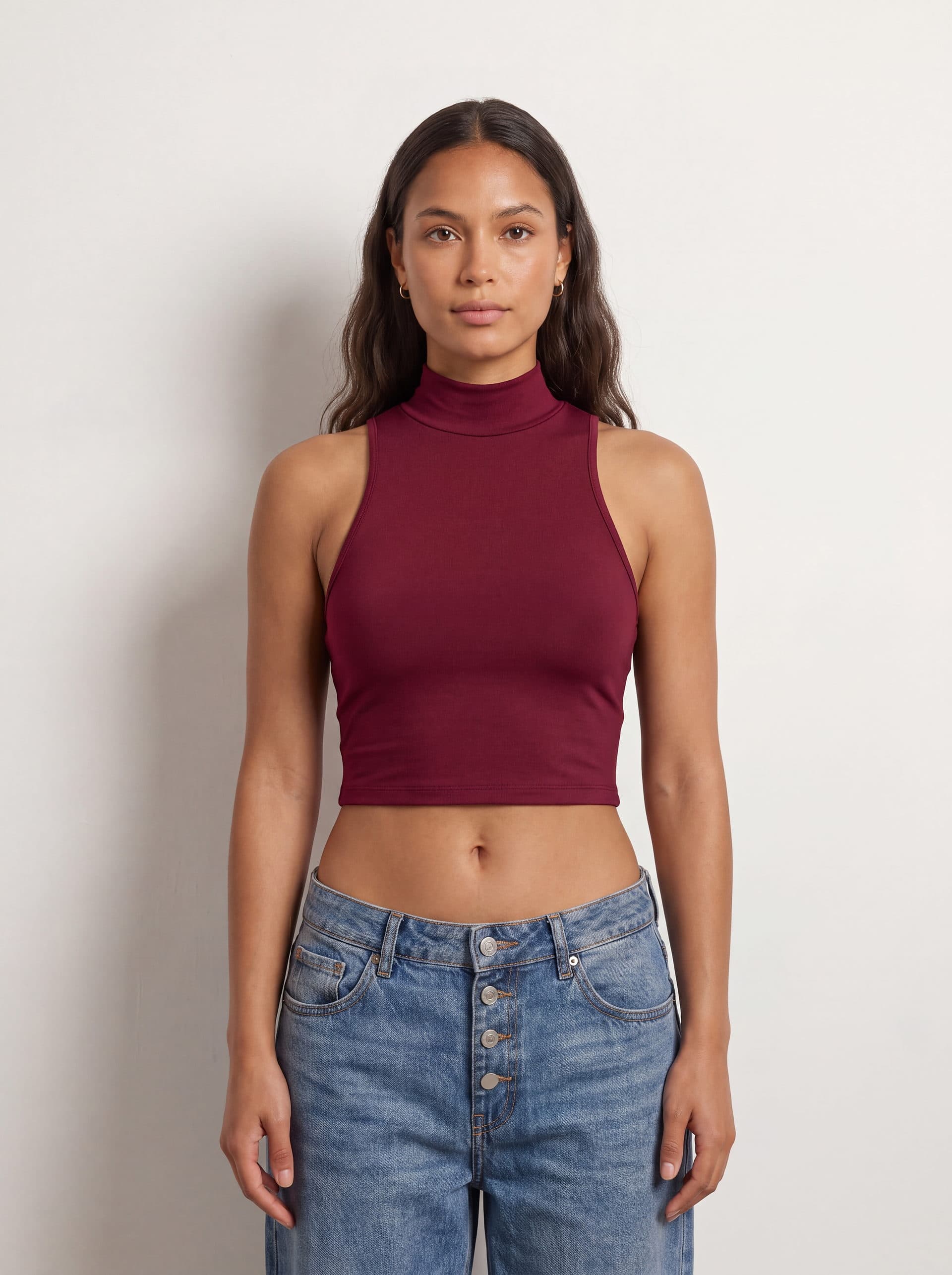 Crop top sin mangas cuello tortuga, en color vino tinto, puesto en modelo