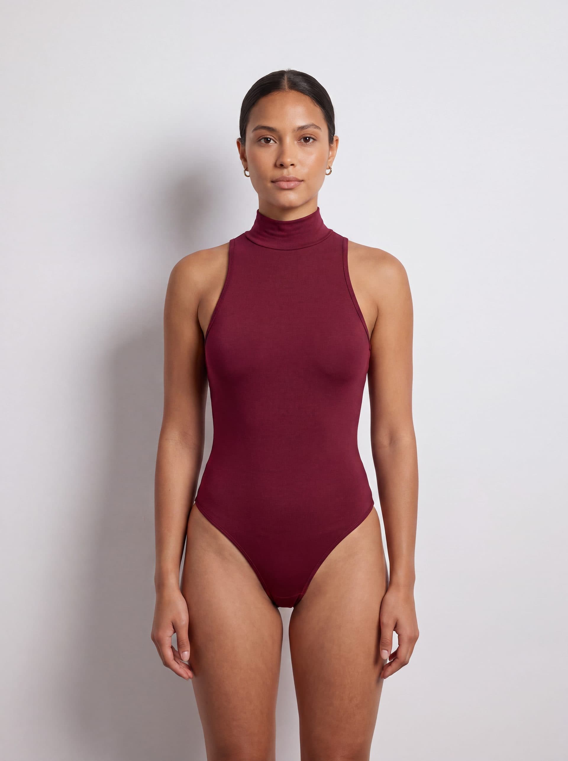Body para dama sin mangas cuello tortuga, en color vino tinto, puesto en modelo