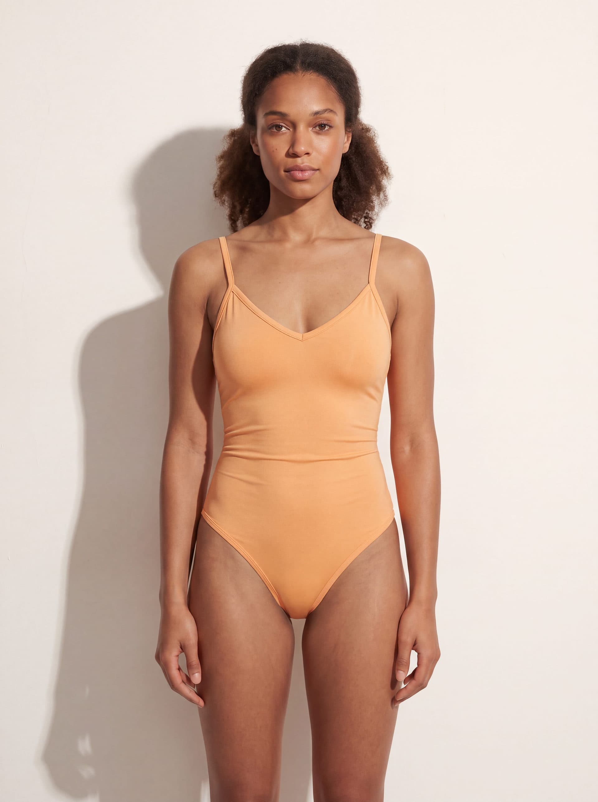 Body para dama con tirantes cuello V, en color durazno, puesto en modelo