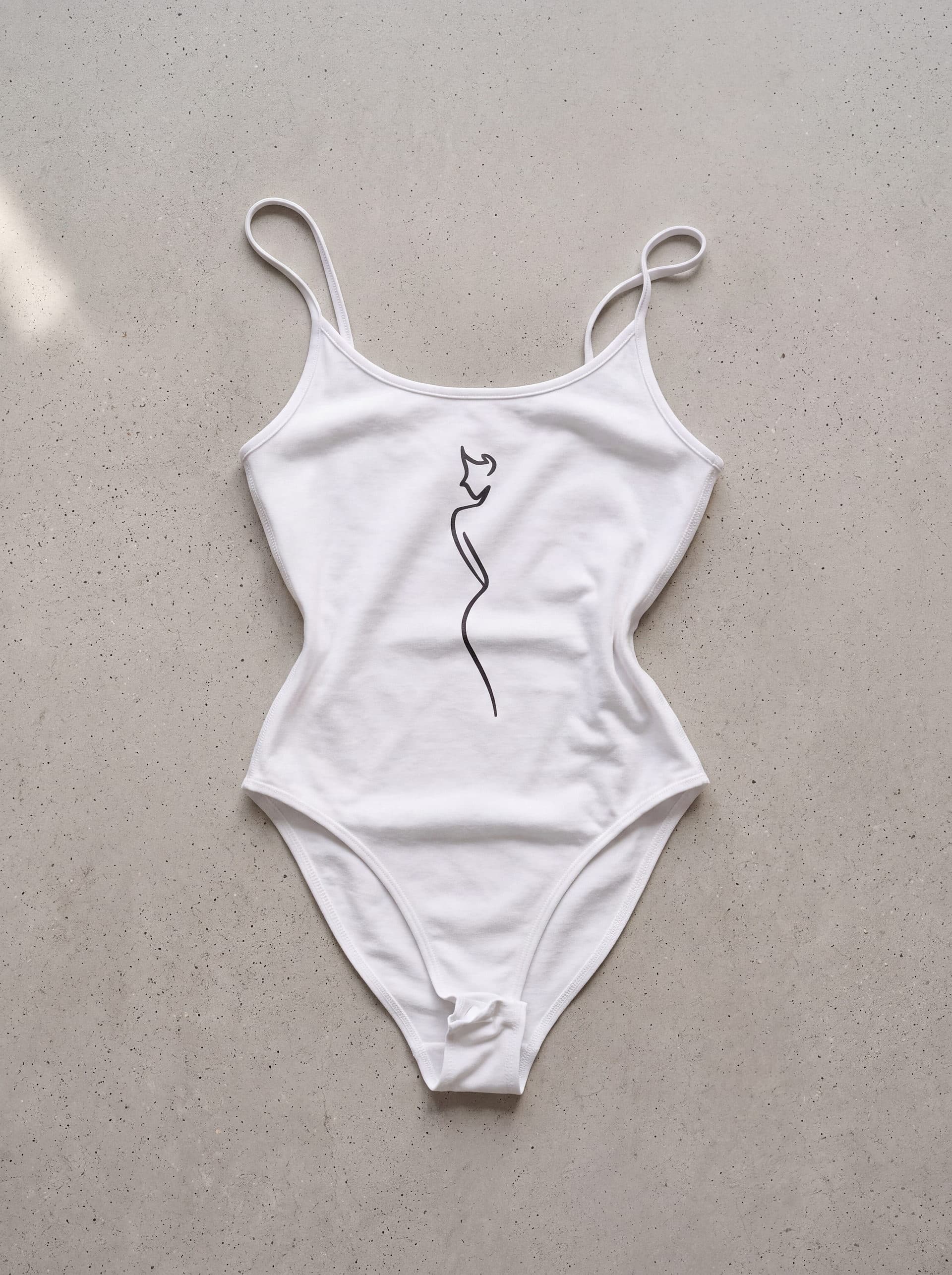 Body tirantes Silueta Mujer, en color blanco, prenda sola sobre fondo de cemento