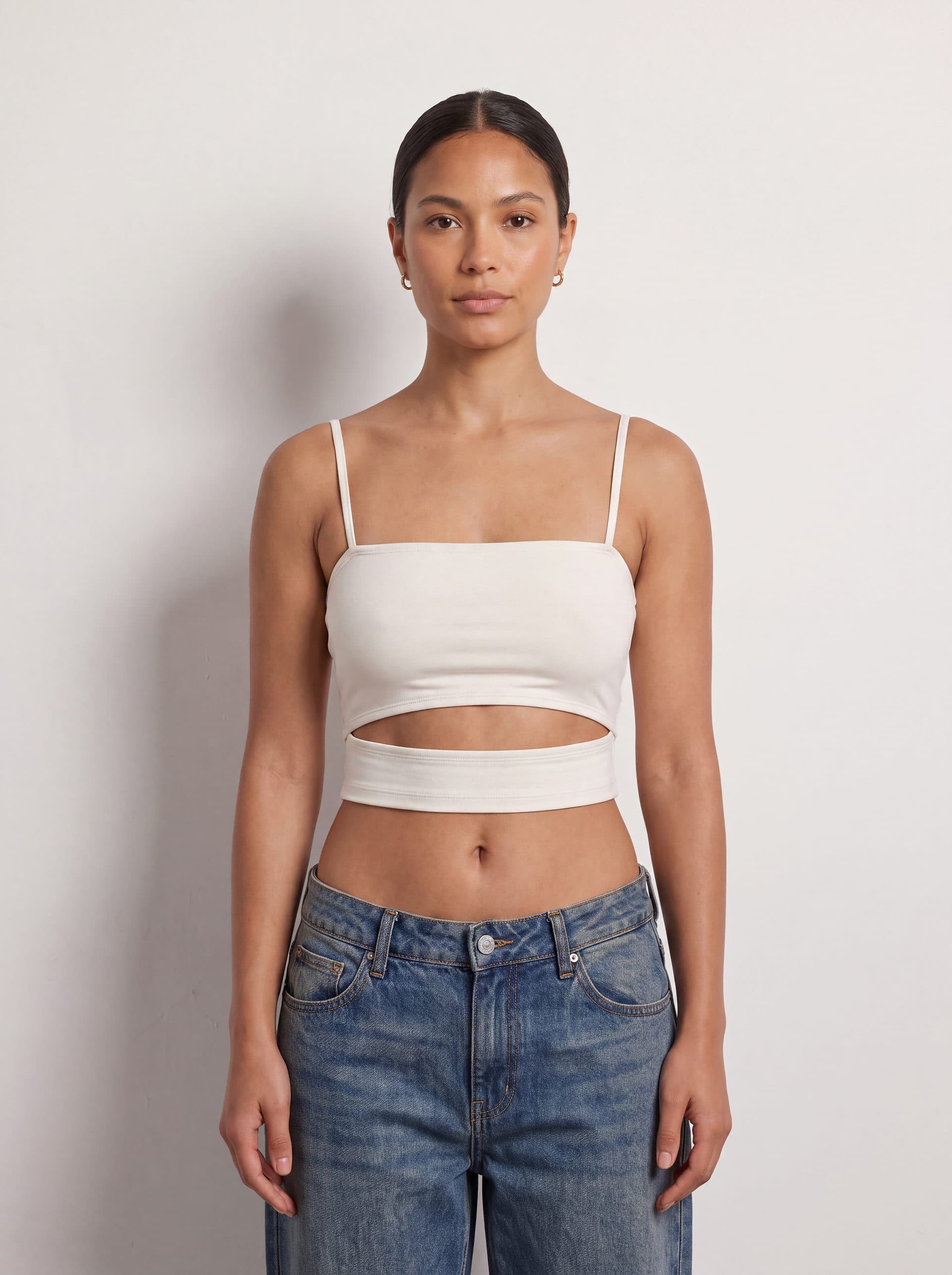 Crop top con abertura en cintura, en color blanco, puesto en modelo
