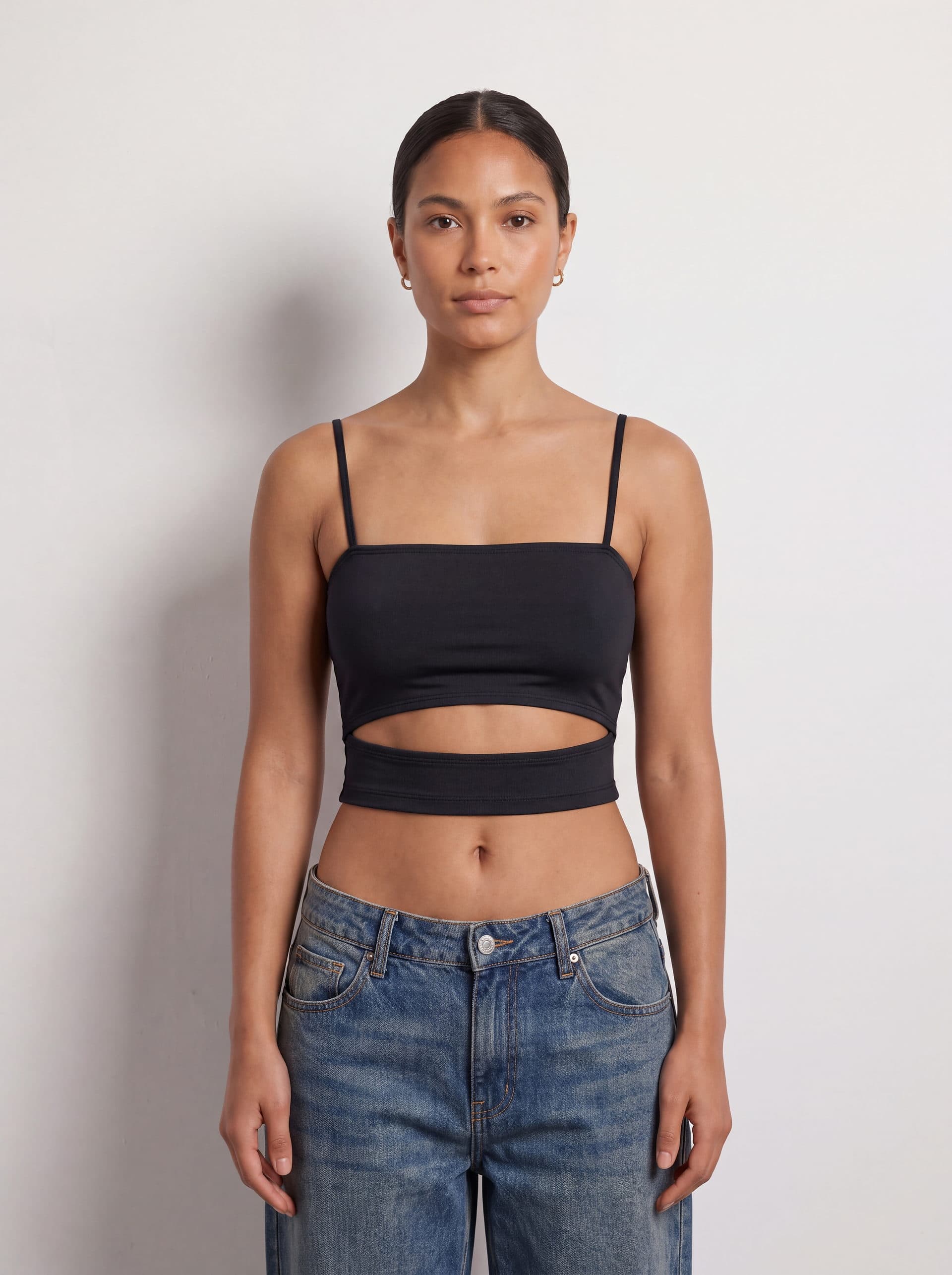Crop top con abertura en cintura, en color negro, puesto en modelo